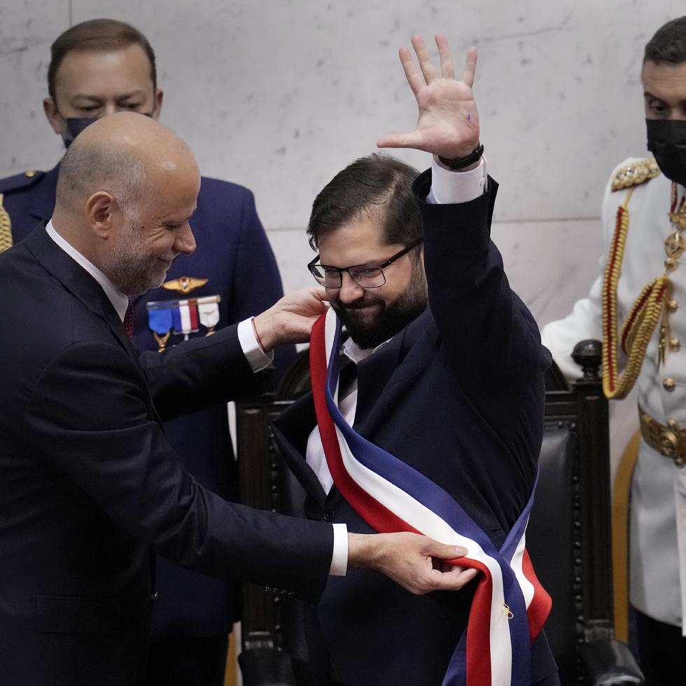 Chile's new President Gabriel Boric receives the presidential sash from Congress President Alvaro Elizalde during his swearing-in ceremony at Congress in Valparaiso, Chile, Friday, March 11, 2022. (AP Photo/Esteban Felix)