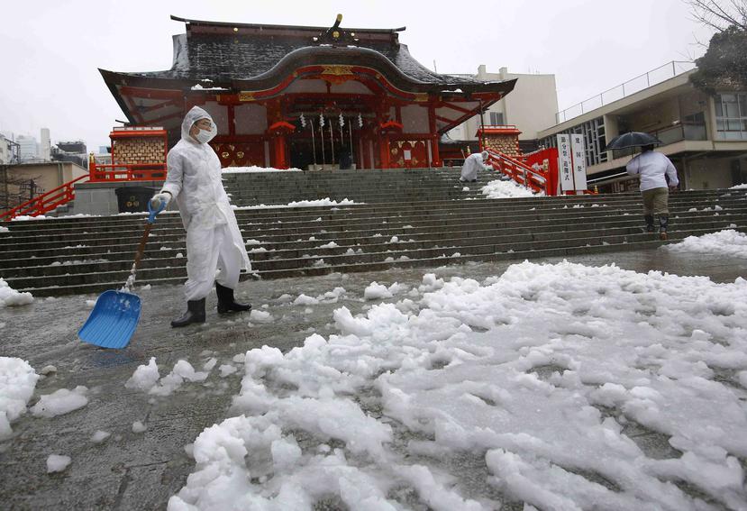 
Varios hombres remueven nieve en un santuario en Tokyo, Japón, golpeado por una gran nevada que ha limitado la transportación en ese país. (AP / Shizuo Kambayashi)

