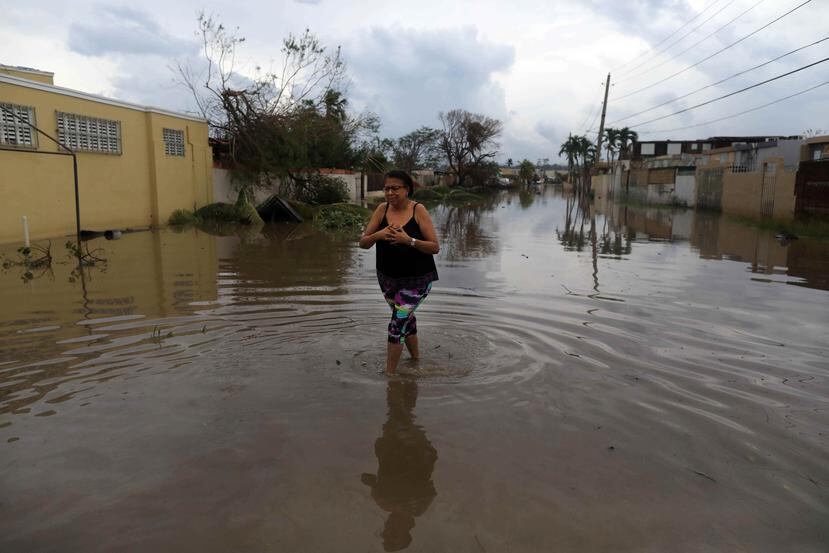 Una mujer camina por una de las calles que se inundaron tras el paso del huracán María en la urbanización Levittown, en Toa Baja. (GFR Media)