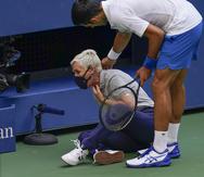 El serbio Novak Djokovic revisa el estado de una jueza de línea a la que asestó un pelotazo en medio de la frustración en el duelo ante el español Pablo Carreño Busta, durante la cuarta ronda del US Open, el domingo 6 de septiembre de 2020, en Nueva York.