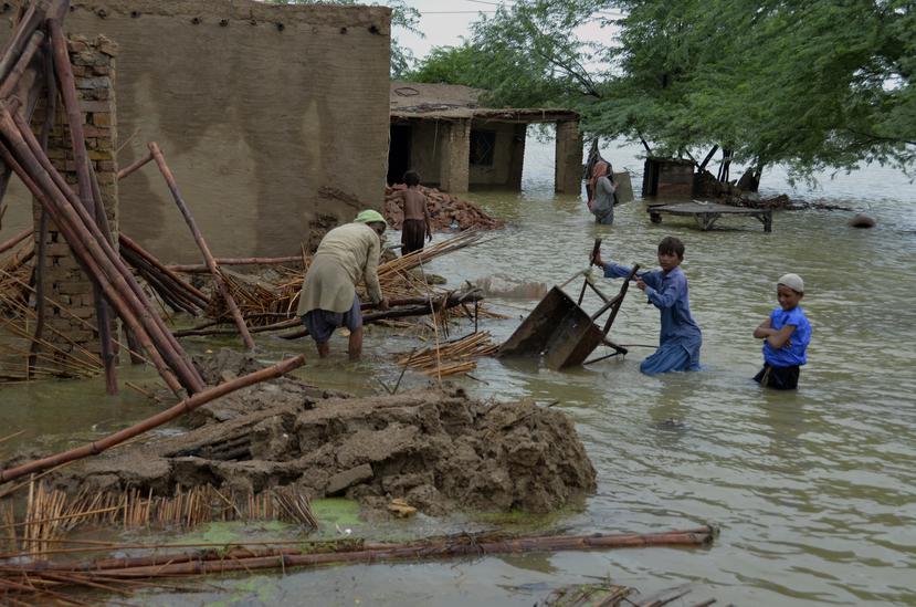 Una familia recupera artículos utilizables de su casa afectada por las inundaciones en Jaffarabad, un distrito de la provincia de Baluchistán, en el suroeste de Pakistán.