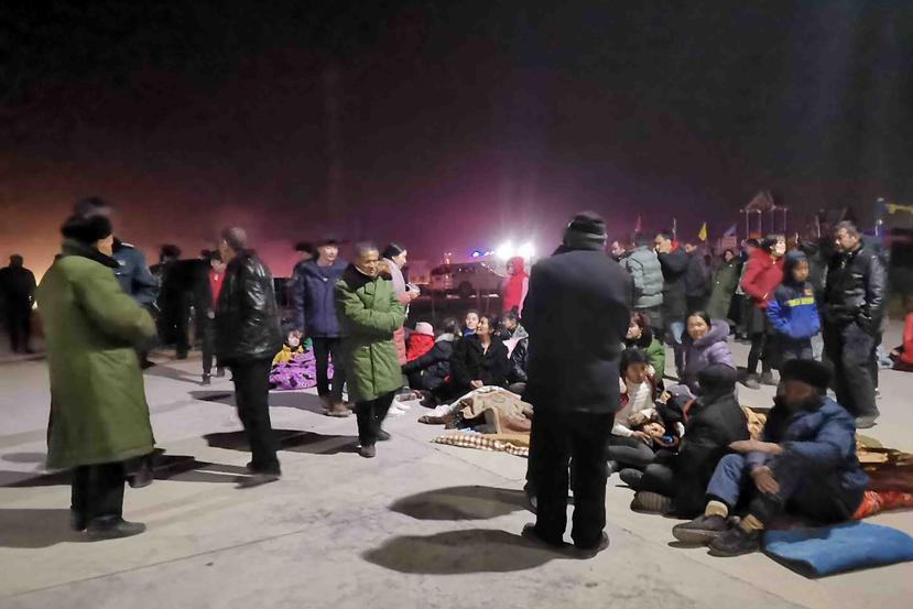 Varias personas a las afueras de los edificios tras el sismo. (Li Chengxin/Xinhua via AP)