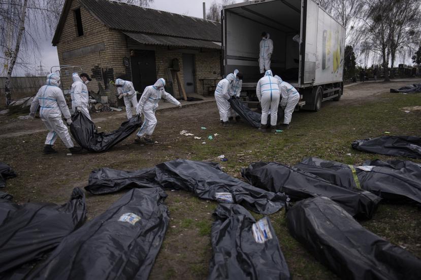 Voluntarios remueven los cuerpos de civiles que murieron durante la ocupación rusa de la ciudad de Bucha, en Ucrania. Los cuerpos fueron transportados para llevar a cabo autopsias forenses como parte de investigaciones de crímenes de guerra.