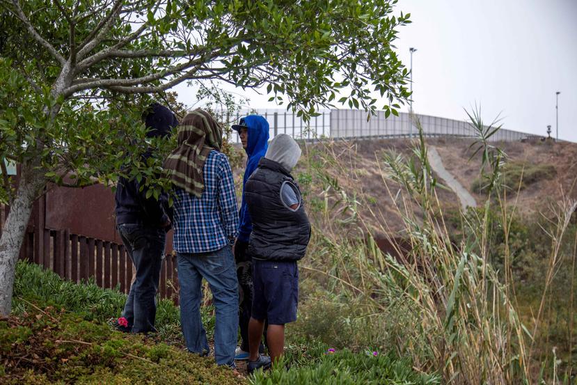 Integrantes de la caravana migrante de centroamericanos recorren el muro fronterizo en la ciudad de Tijuana, México. (EFE)