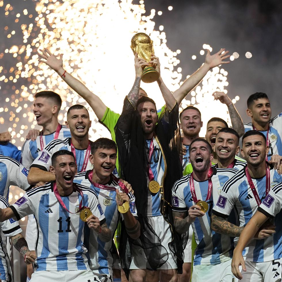 El argentino Lionel Messi (con una túnica negra) alza la Copa del Mundo tras vencer en la final a Francia, el 18 de diciembre de 2022, en Lusail, Catar.