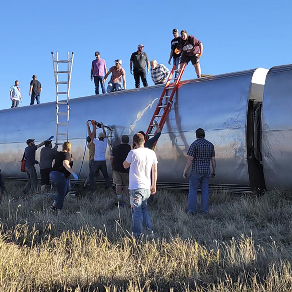 En esta fotografía de Kimberly Fossen, varias personas trabjan en el lugar donde se descarriló un tren de Amtrak en el centro norte de Montana, el sábado 25 de septiembre de 2021.