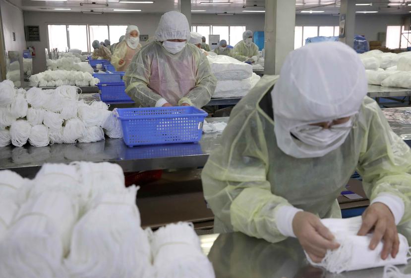 Varias personas trabajan en una fábrica de mascarillas este lunes en Nantong (China). (EFE)