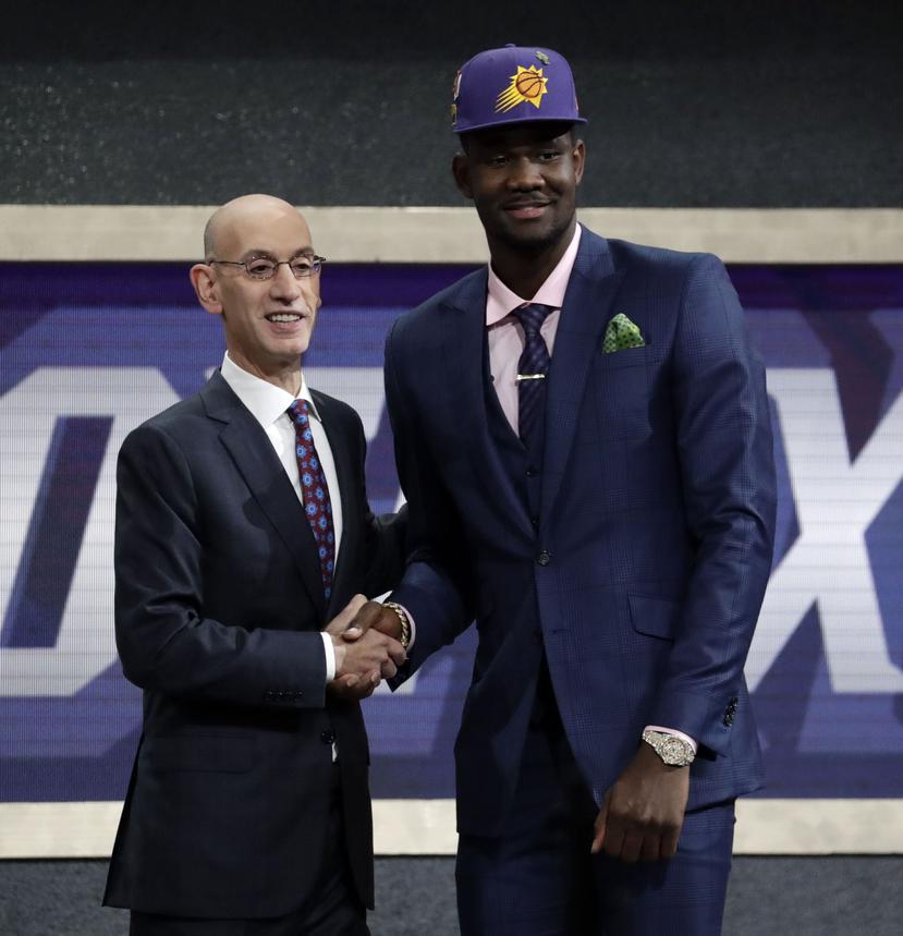 El comisionado de la NBA, Adam Silver, le da la mano con Deandre Ayton, elegido número uno por los Suns en la primera ronda del draft de la NBA.