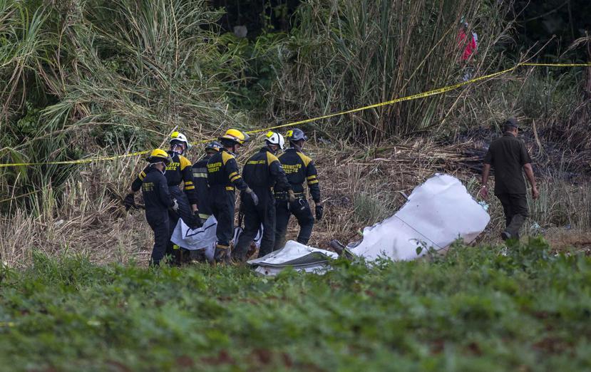 Rescatistas cubanos recuperan un cuerpo en la zona donde se estrelló el avión. (AP)