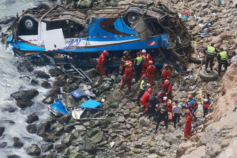 Un grupo de bomberos y policías durante las labores de rescate del  autobús siniestrado en Perú (EFE). 
