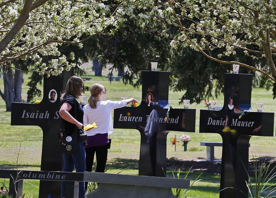 Una familia visita las cruces conmemorativas dedicadas a las 13 víctimas del ataque en Columbine, el 20 de abril de 2014.
