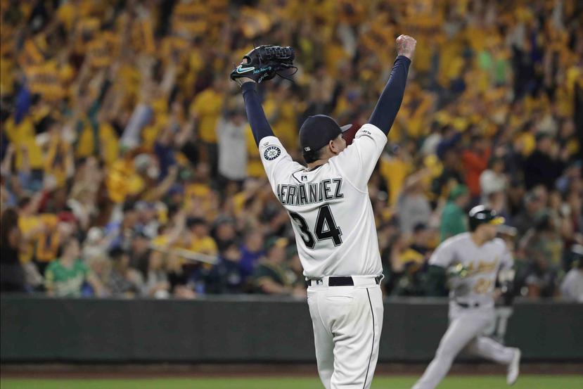 El abridor de los Marineros de Seattle, Félix Hernández, celebra tras superar una situación con las bases llenas al final del quinto inning del juego de la MLB que enfrentó a su equipo con los Atléticos de Oakland. (AP)
