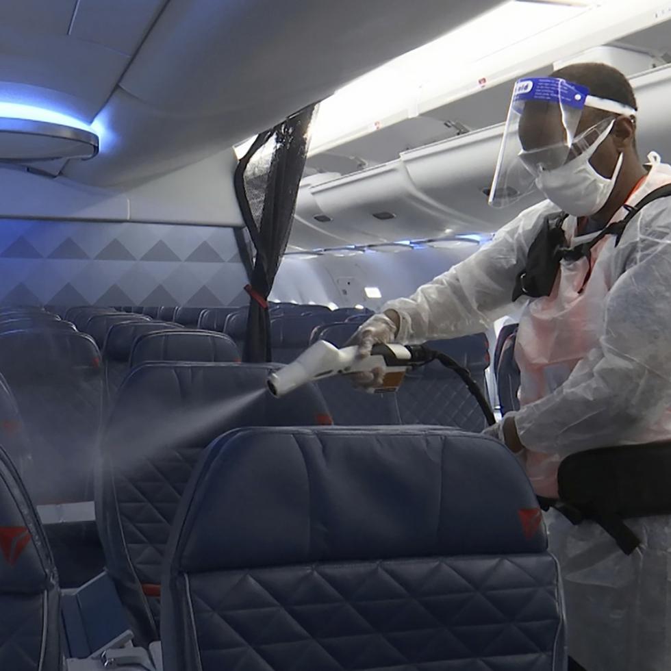 Melaku Gebermariam desinfecta los asientos de un avión de Delta el 22 de julio del 2020 en el aeropuerto Ronald Reagan de Washington.