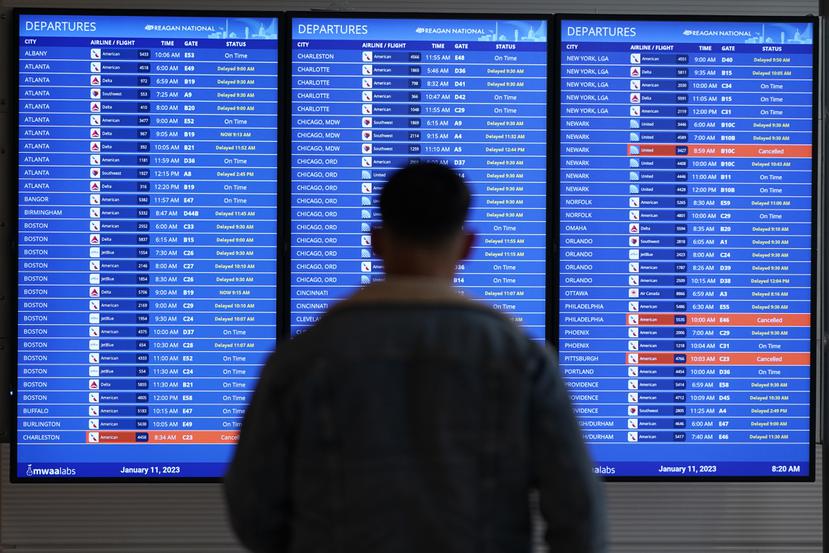 Un pasajero ve la pantalla del estatus de los vuelos en el aeropuerto Ronald Reagan, en Arlington.