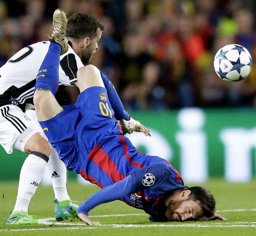 Lionel Messi del Barcelona cae a la cancha al pugnar un balón con Miralem Pjanic (izquierda) de la Juventus en el partido. (AP)