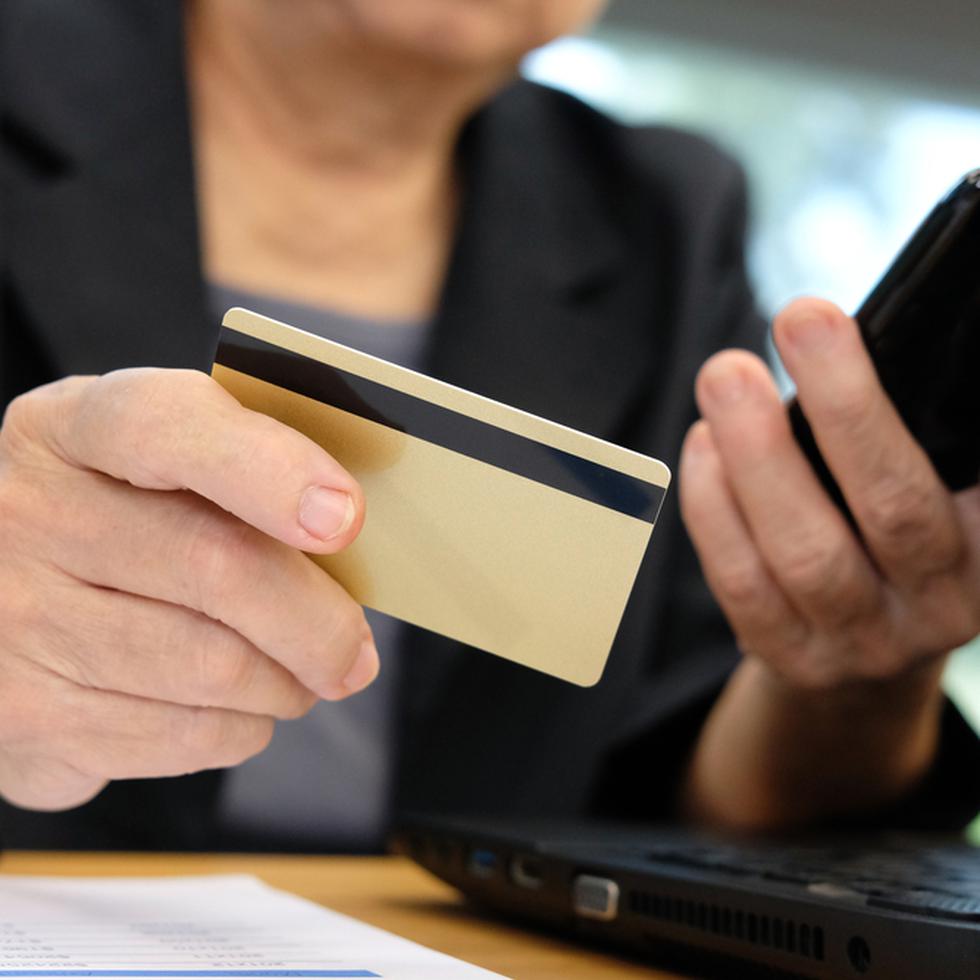 mujer con tarjeta de crédito y celular