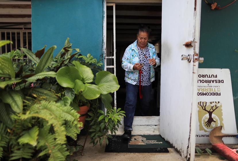 Para entrar y salir de su casa, Gladys Peña tiene que cruzar un muro de dos bloques de alto.