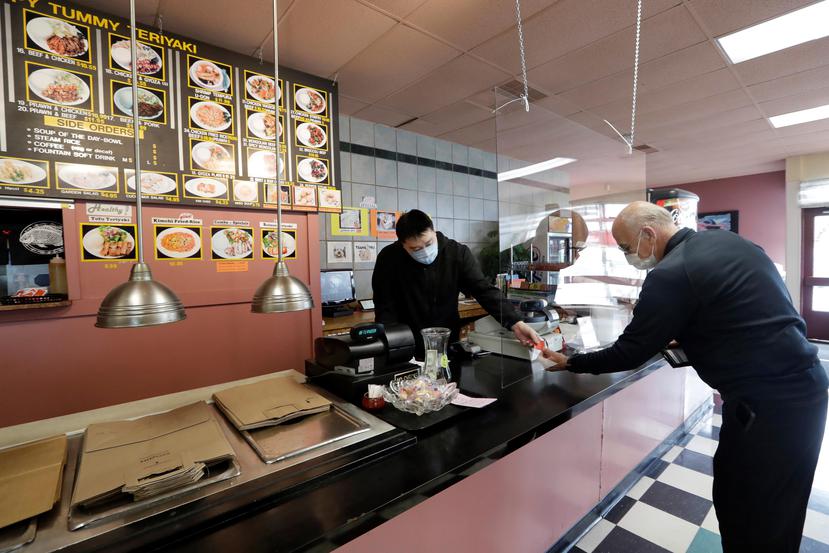 En ciudades como Seattle, Washington, los restaurantes están operando y sus empleados utilizan mascarillas para atender al público. (AP / Elaine Thompson)