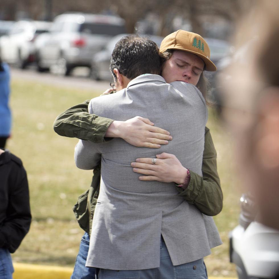 Un alumno, a la derecha, abraza a un padre al reunirse después de un tiroteo escolar en la East High School, el miércoles.