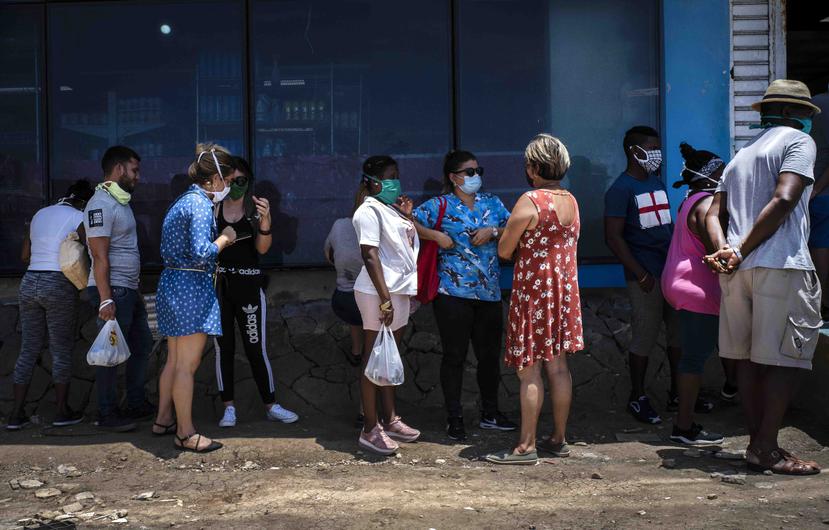 Personas con máscaras hacen fila para ingresar a una tienda de alimentos administrada por el gobierno en La Habana, Cuba. (AP)