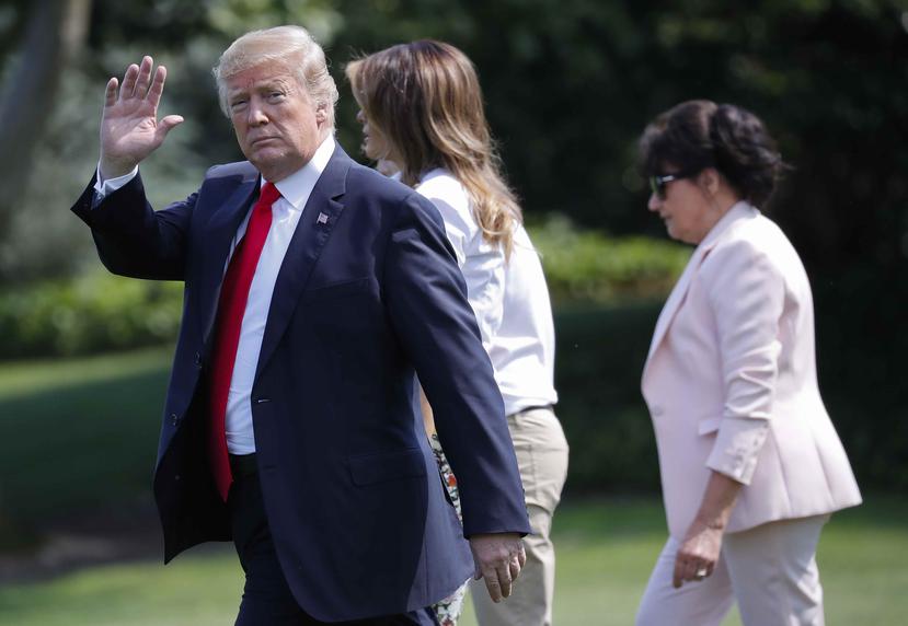 El presidente Donald Trump, saluda a la gente mientras camina por el jardín de la Casa Blanca en Washington, acompañado de la primera dama Melania Trump, centro, y Amalija Knavs, derecha, madre de Melania Trump. (AP)