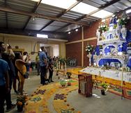 Varias personas visitan altares durante la celebración de Día de Muertos, el 1 de noviembre de 2022, en el municipio de Huaquechula, en Puebla, México. (EFE/ Hilda Ríos)
