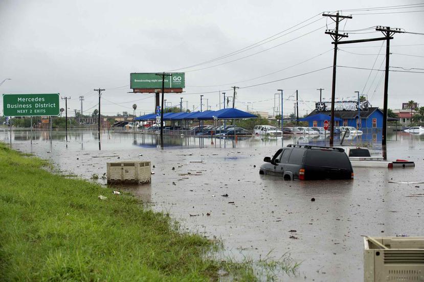 Unos autos abandonados aparecen en medio de una zona inundada, el miércoles 20 de junio del 2018. (AP)