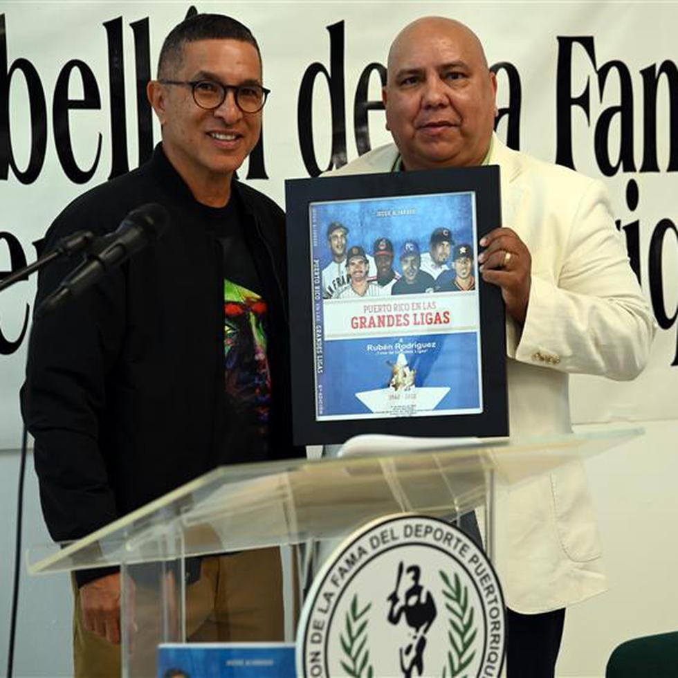 Jossie Alvarado, autor de Puerto Rico en las Grandes Ligas, entregó un afiche conmemorativo al periodista Rubén A. Rodríguez, a quien se le dedicó la presentación del libro.