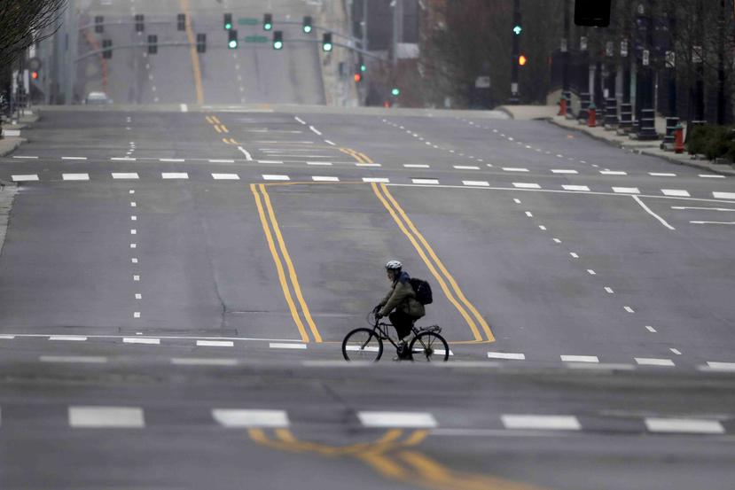 Un ciclista se desplaza por una avenida vacía en el centro de Kansas City, Missouri. (AP)