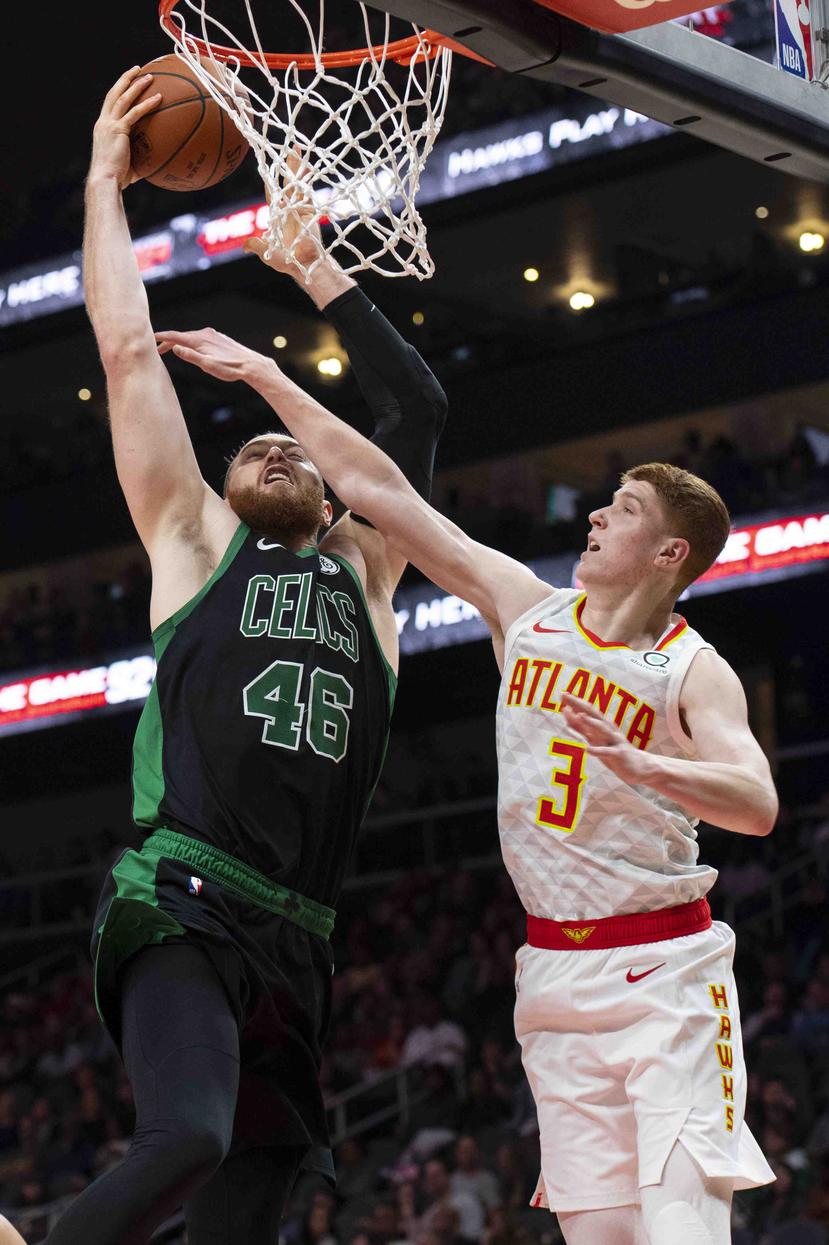 El pívot de los Celtics de Boston, Aron Baynes (46), hace un tiro sobre el escolta de los Hawks de Atlanta, Kevin Huerter. (AP)