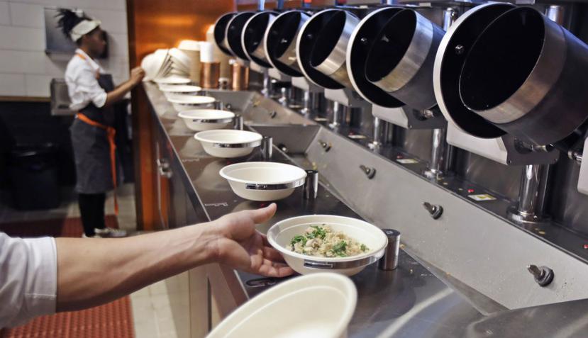 Un cliente se sirve una ensalada usando un sistema automatizado en Spyce, un restaurante de Boston. (AP)