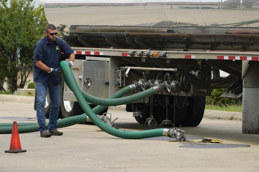 El conductor de un camión cisterna ajusta su manguera a un tanque subterráneo, el 24 de mayo de 2022, en Jackson, Mississippi.