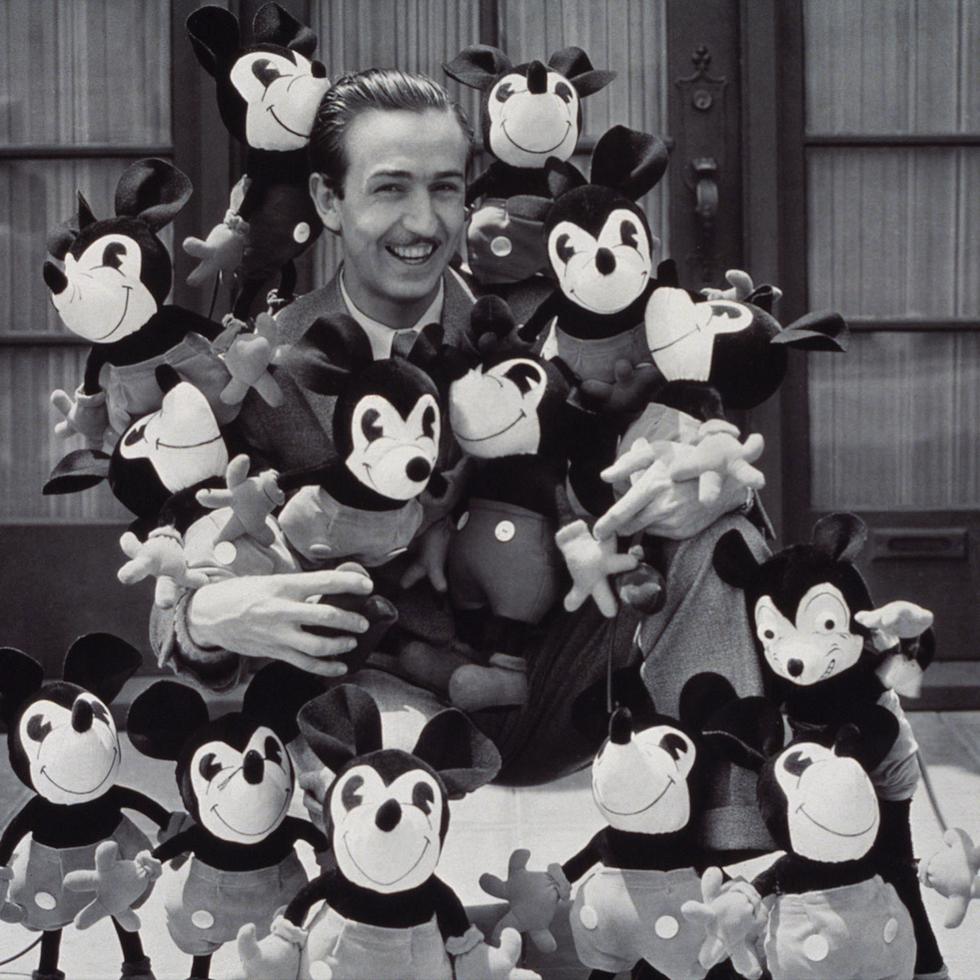 Foto de Walt Disney rodeado de muñecos de Mickey Mouse.