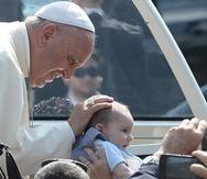 El papa Francisco toca la cabeza de un bebé antes de realizar un mensaje a un grupo de jóvenes en Italia en septiembre de 2019.