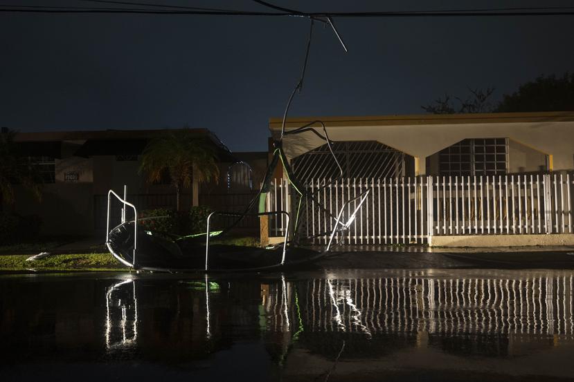 Un trampolín terminó anoche enganchado en una cablería eléctrica de la urbanización La Matilde de Ponce tras el paso del huracán Fiona.