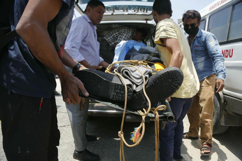 Personal médico carga el cuerpo de uno de dos montañistas indios que fallecieron subiendo el monte Kanchenjung, en Nepal, el domingo 19 de mayo de 2019. (AP / Niranjan Shrestha)