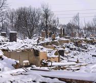 La nieve cubre los restos de viviendas destruidas por un incendio forestal en Mulberry Street, el sábado 1 de enero de 2022, en Louisville, Colorado.