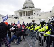 FILE - Insurrectionists loyal to President Donald Trump try to break through a police barrier, Wednesday, Jan. 6, 2021, at the Capitol in Washington. Top House and Senate leaders will present law enforcement officers who defended the U.S. Capitol on Jan. 6, 2021, with Congressional Gold Medals on Wednesday, Dec. 7, 2022, awarding them Congress's highest honor nearly two years after they fought with former President Donald Trump’s supporters in a brutal and bloody attack. (AP Photo/Julio Cortez, File)