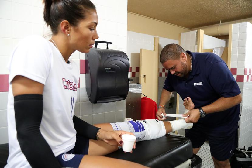 Víctor Correa le venda el tobillo izquierdo a Karina Ocasio previo a un reciente partido de la serie final entre las Valencianas de Juncos y las Criollas de Caguas.