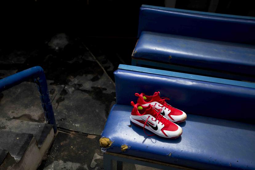 La imagen muestra un par de zapatos nuevos de béisbol, encima de un viejo banquillo en la cueva de los Tiburones de La Guaira, antes del primer juego de la temporada ante los locales Leones del Caracas. (AP)