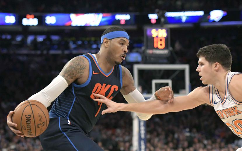 Carmelo Anthony, en su regreso a Nueva York,  busca llegar al canasto contra Doug McDermott. (AP)