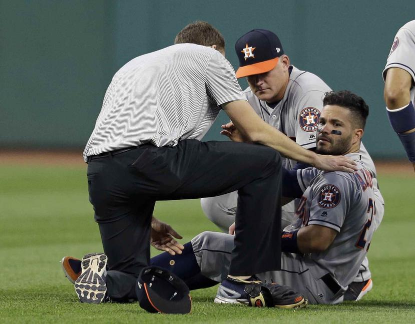 José Altuve es atendido por personal médico de los Astros de Houston luego de chocar con Teóscar Hernández. (AP / Tony Dejak)