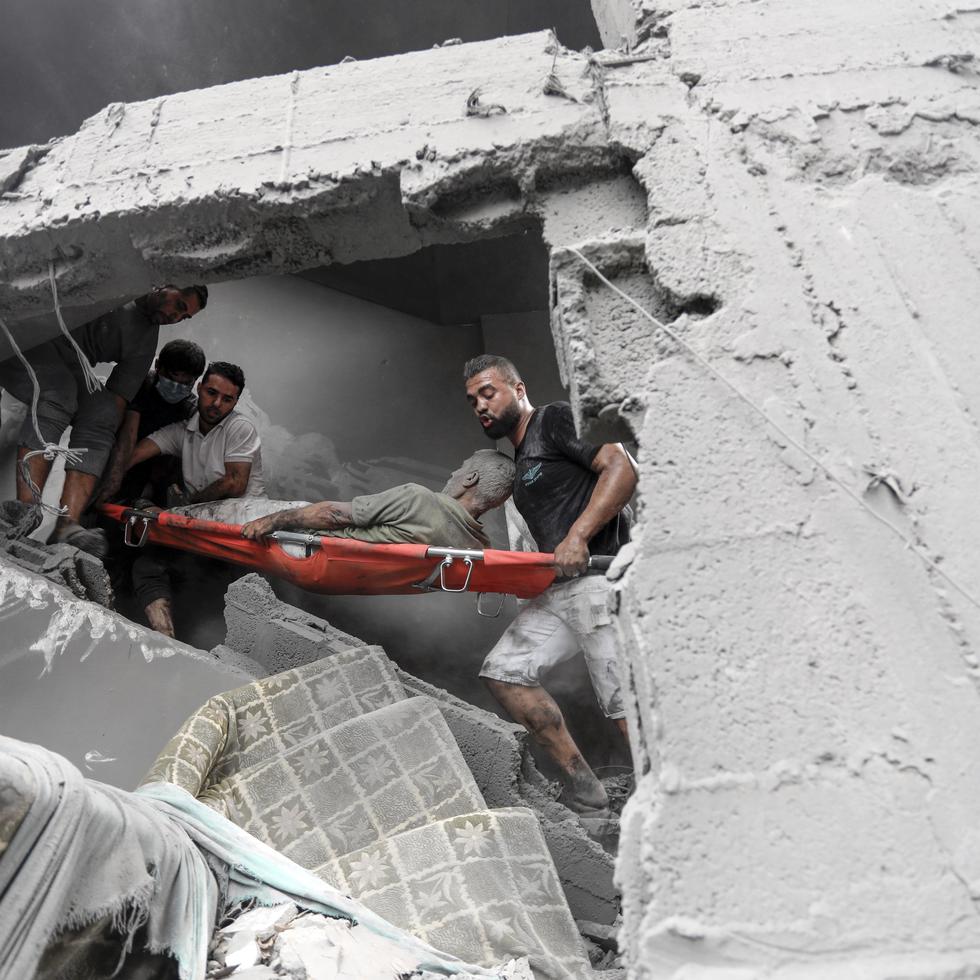 Palestinos sacan a un hombre herido de la destrucción tras los ataques aéreos israelíes en la ciudad de Gaza, el 27 de octubre de 2023.