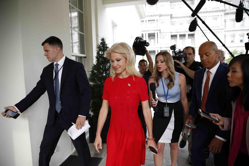 Kellyanne Conway, consejera del presidente Donald Trump, (traje rojo) va camino a una reunión con el primer mandatario estadounidense. (AP / Alex Brandon)