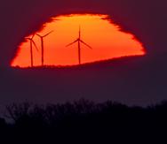 En esta imagen del 11 de marzo de 2022, se ven turbinas eólicas frente al Sol, que sale por el horizonte en Fráncfort, Alemania.