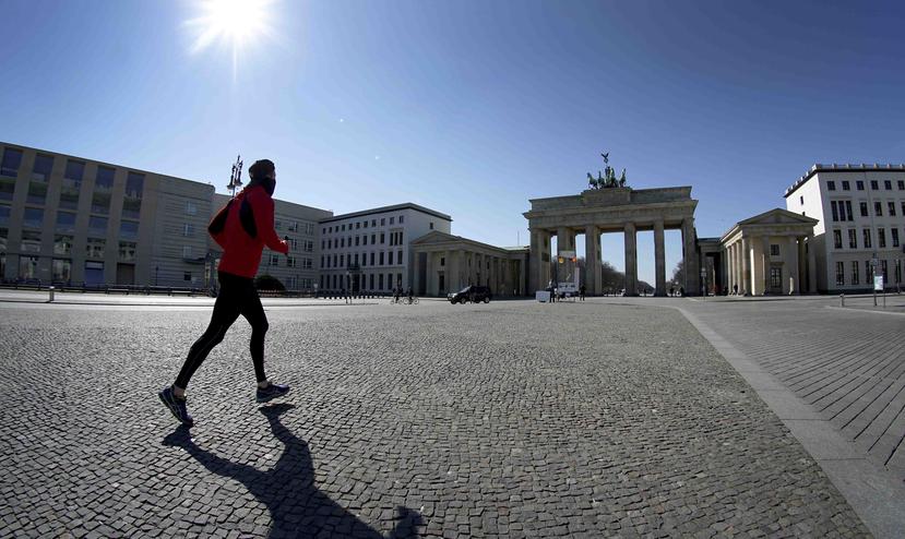 Un hombre corre en la plaza frente a la Puerta de Brandenburgo en Berlín. (AP)