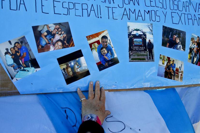 Una mujer toca un póster cubierto con fotografías de los miembros de la tripulación del submarino desaparecido (AP).