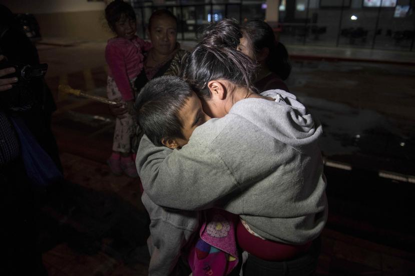 Anthony David Tovar Ortiz, izquierda, es abrazado por una pariente tras llegar al aeropuerto La Aurora en Ciudad de Guatemala. El niño de 8 años permaneció en un albergue para niños migrantes en Houston después de que su madre Elsa Ortiz Enríquez fue depo