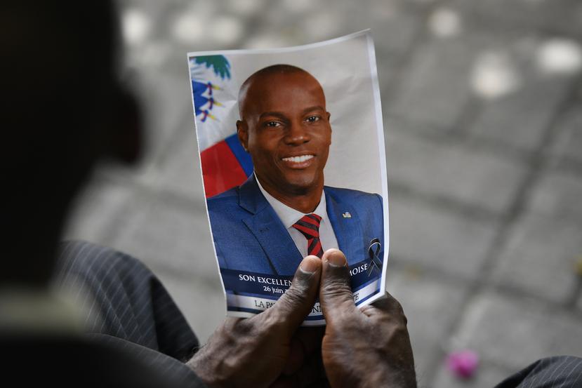 Una persona sostiene una fotografía del difunto presidente Jovenel Moïse durante una ceremonia fúnebre el 20 de julio de 2021, en el Museo y Cementerio Nacional en Puerto Príncipe, Haití.