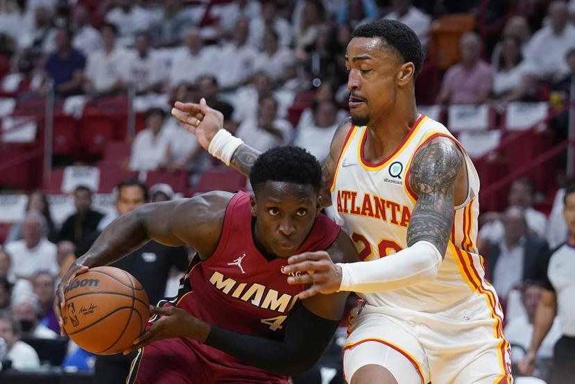El base del Heat de Miami Victor Oladipo avanza hacia la canasta mientras lo defiende el alero de los Hawks de Atlanta John Collins.